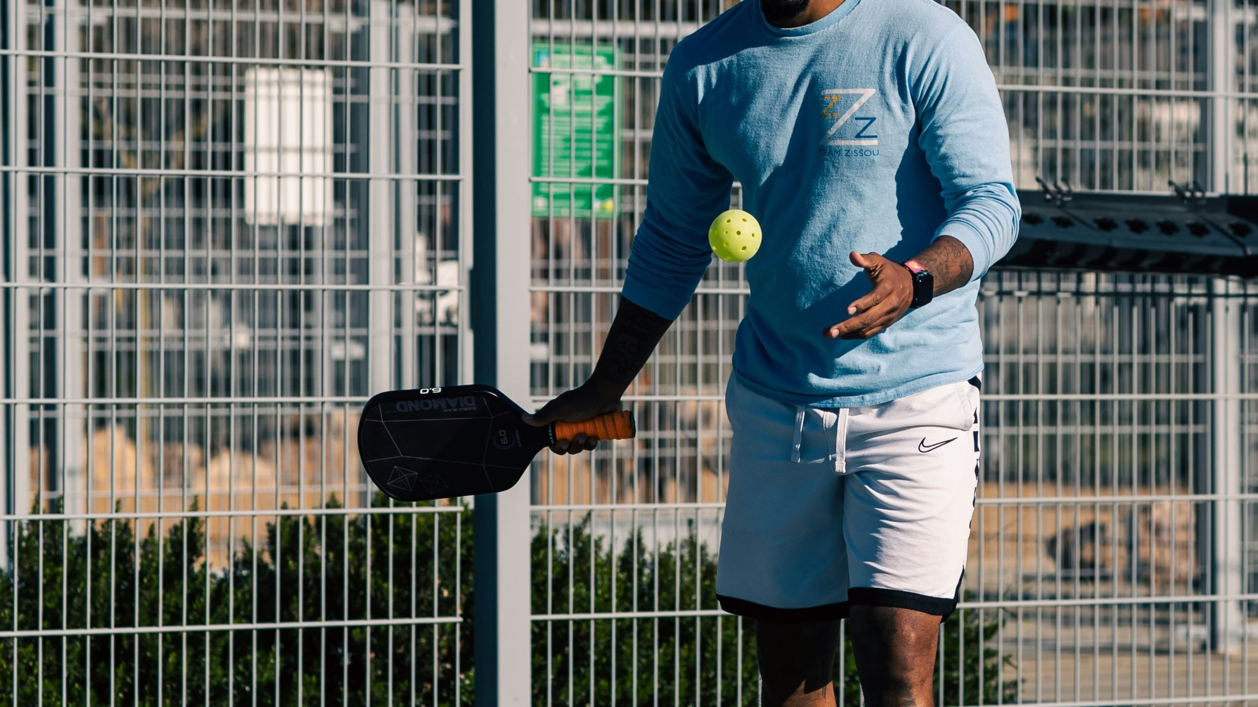 A player holding a pickleball and a paddle