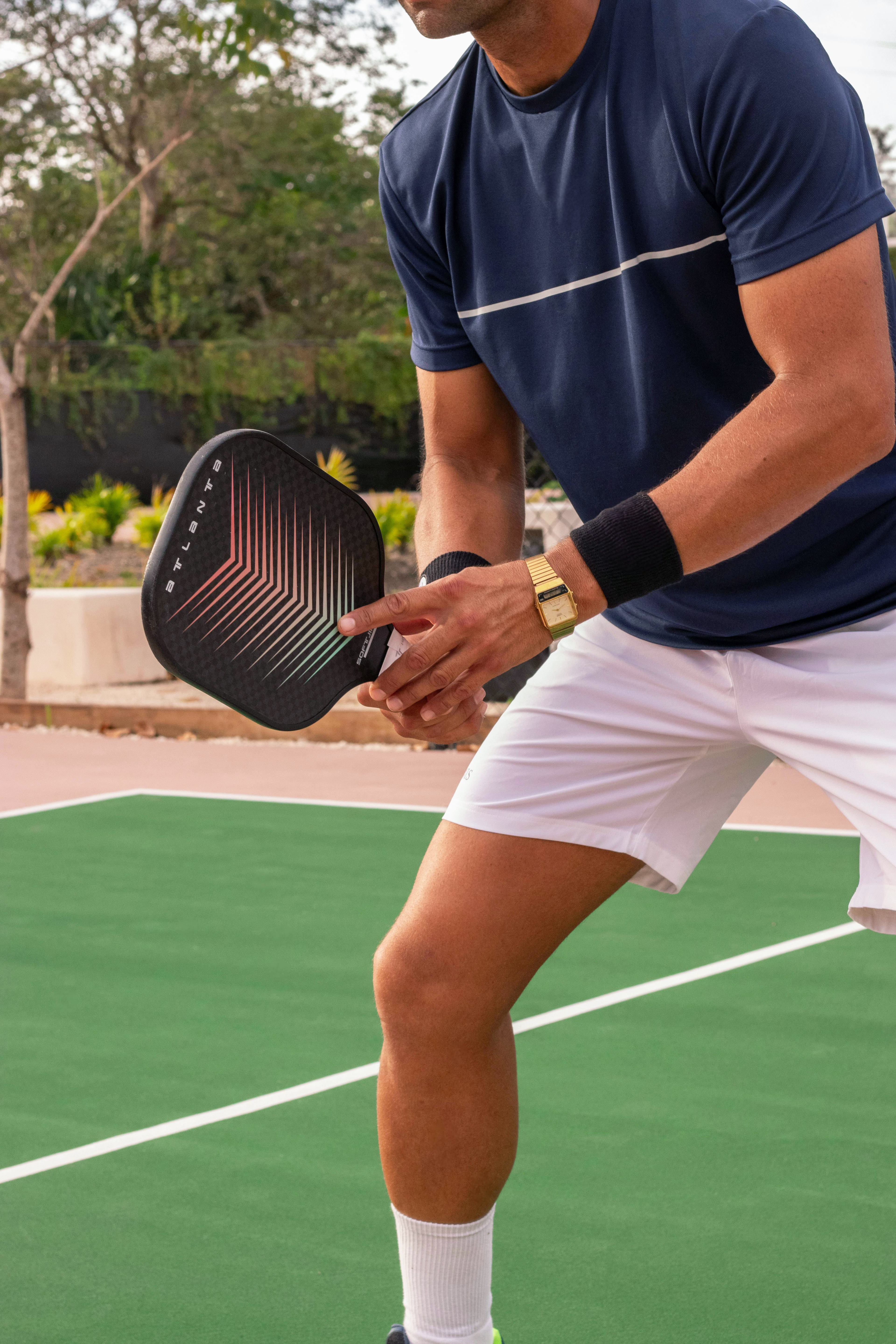 A player holding a pickleball and a paddle